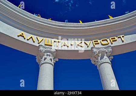 Alushta - resort as welcome message on white colonnade with blue sky and white clouds in Alushta, Crimea, Ukraine. Europe travel diversity Stock Photo