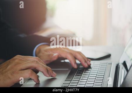 Businessman hand using laptop computer typing keyboard close-up. Online work. Internet. Planning research report at office. Stock Photo