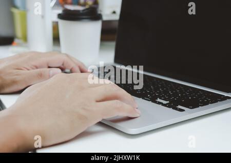 Man person hand using laptop computer keyboard.business technology network internet online at office. Stock Photo