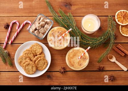glasses of eggnog, oatmeal cookies and fir branch Stock Photo