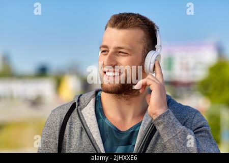 man in headphones listening to music outdoors Stock Photo