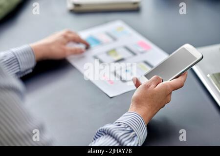 hands with phone working on ui design at office Stock Photo