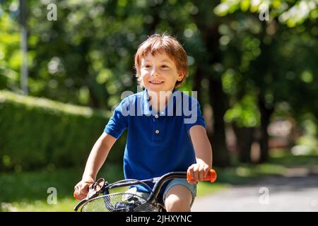 happy little boy riding bicycle at summer park Stock Photo