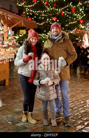 family with takeaway drinks at christmas market Stock Photo