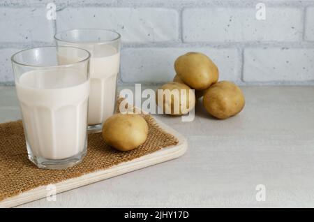 Two glass glasses with potato milk. Rustic style. A new trend in eating healthy. Alternative food concept. Vegetable Milk for Vegans. horizontal orien Stock Photo