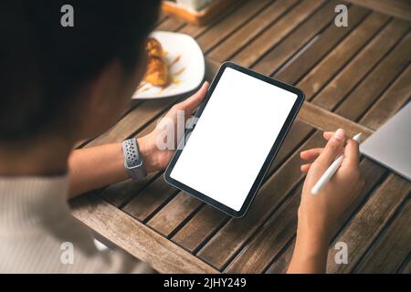 close-up women holding digital tablet white screen and stylus pen on table Stock Photo