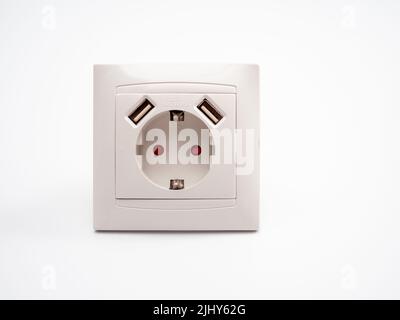 Universal European standard 220 volt socket with two usb connectors for charging mobile devices. White plastic socket on a white background. Stock Photo