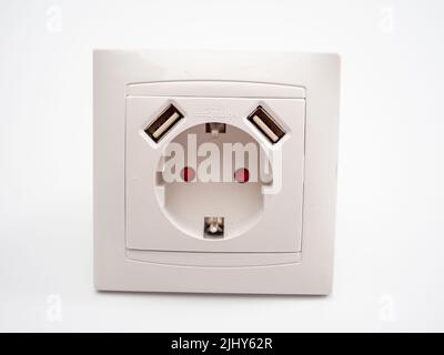 Universal European standard 220 volt socket with two usb connectors for charging mobile devices. White plastic socket on a white background. Stock Photo