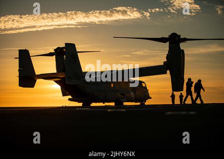 Cadiz, Spain. 15 July, 2022. A U.S. Marines MV-22 Osprey tilt-rotor aircraft assigned to the Aviation Combat Element, 22nd Marine Expeditionary Unit is silhouetted by the sun on the flight deck of the Wasp-class amphibious assault ship USS Kearsarge sailing in the Atlantic Ocean, July 15, 2022 near Cadiz, Spain.  Credit: Sgt. Armando Elizalde/U.S. Marine Corps/Alamy Live News Stock Photo