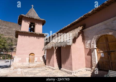 The bell tower and carved stone portal of the side entrance of the Saint Francis of Assisi Church in Socoroma, Chile. Stock Photo