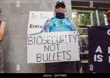 London, England, UK. 21st July, 2022. A protester holds a ''Biosecurity not bullets'' sign. Activists gathered outside DEFRA (The Department for Environment, Food and Rural Affairs) in protest against the ongoing badger cull, which is part of the UK Government's policy against the spread of bovine tuberculosis. Scientists and activists insist that the killing of the wild animals is unnecessary, cruel, and ineffective against the spread of bovine TB. (Credit Image: © Vuk Valcic/ZUMA Press Wire) Stock Photo