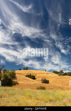 Dramatic wispy clouds over the golden hills near Sutter Creek, California Stock Photo