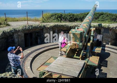American tourists having their photo taken by the German Second World War gun emplacement at Batterie Generaloberst Dollman, Pleinmont, Guernsey Stock Photo