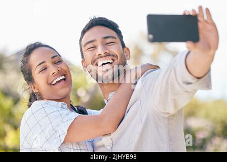 We love showing off our love. a young couple taking a selfie while spending time together outdoors. Stock Photo