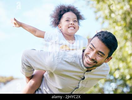 The memories we make with our family is everything. man giving his daughter a piggyback ride. Stock Photo