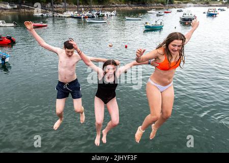 Schull, West Cork, Ireland. 21st July, 2022. On a warm and humid day with temperatures in Schull at 20C, Thomas and Chloe Creagh, Trim and Eve McDonald from Cork jump into the water off Schull Pier to cool down. Credit: AG News/Alamy Live News Stock Photo