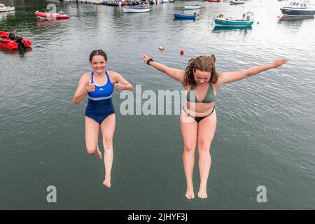 Schull, West Cork, Ireland. 21st July, 2022. On a warm and humid day with temperatures in Schull at 20C, Áine ORegan, Schull and Ella Camier from Ballydehob jump into the water off Schull Pier to cool down. Credit: AG News/Alamy Live News Stock Photo