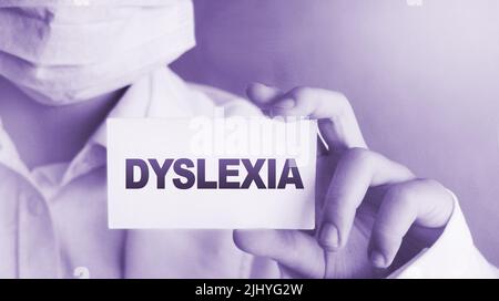 Dyslexia word on card. Doctor keeps a card with the name of the diagnosis dyslexia. Selective focus. Medical concept. Stock Photo