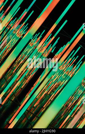 Abstract orange and green LED light poles at angle Stock Photo