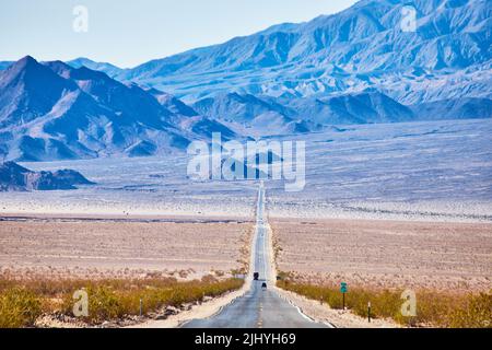 View of long endless road going up into desert mountains Stock Photo