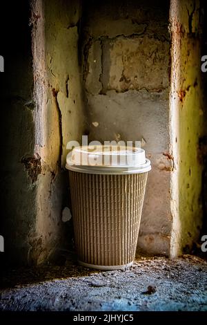 Discarded paper cup in derelict building. Stock Photo