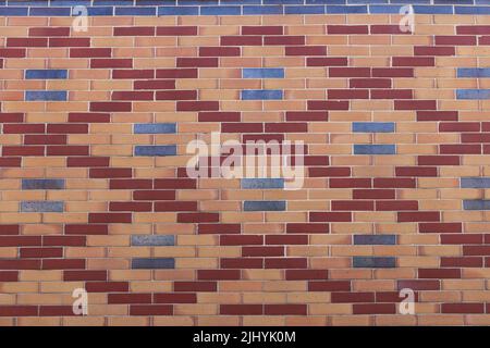 Stone wall background with pattern of blue, red and yellow bricks Stock Photo