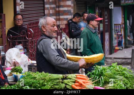Darjeeling, West Bengal, India. June 22, 2022. A village man sitting on the road side of a busy area in Bagdogra for sell his vegetables. Stock Photo