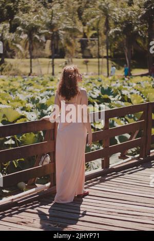 woman in flowing dress walking through the park Stock Photo