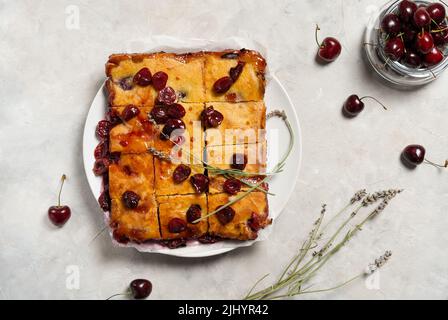 Fresh baked sweet cherry pie or red brownie cake on plate with lavender and raw berries aside. Stock Photo