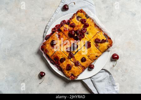 Fresh baked sweet cherry pie or red brownie cake on plate with lavender and raw berries aside. Stock Photo