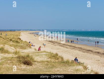 People enjoying Knoll Beach during a spring day on the south coast of England. Stock Photo