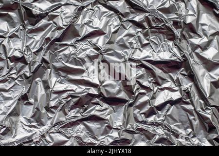 crumpled aluminium foil flat background and texture. Stock Photo