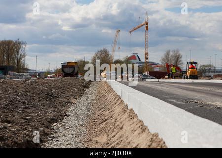 curbstone on road construction site. New curbs after paving. Road repairs-sand rubble base Stock Photo