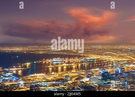 Scenic view of Cape Town at night from Signal Hill in South Africa. Beautiful landscape view of the city lights and buildings against a dark and Stock Photo