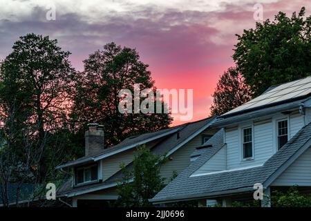 Colorful sunset sky behind suburban Washington, DC rooftops. Stock Photo