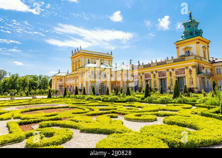 Garden topiary and ornate yellow exterior of Italian style 17th century baroque royal Wilanow Palace, Warsaw, Poland Stock Photo
