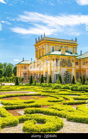 Garden topiary and ornate yellow exterior of Italian style 17th century baroque royal Wilanow Palace, Warsaw, Poland Stock Photo