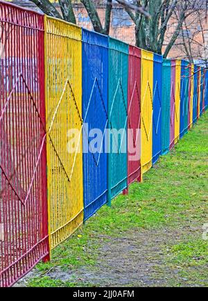 rainbow color long metal fence line, restricted zone diversity Stock Photo