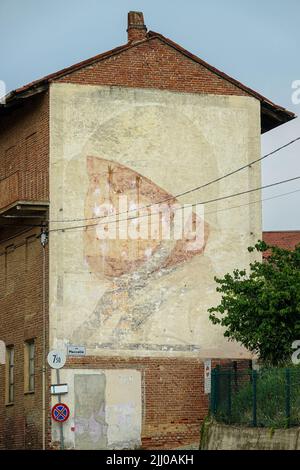 Giant portrait of Benito Mussolini made in 1936 still visible on the side facade of a building.  Montà d'Alba, Italy - July 2022