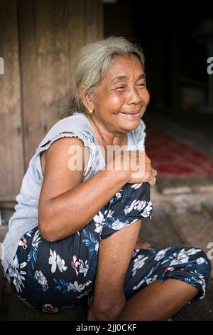 Chini, Malaysia: 19 April 2022 - A single indigenous woman sitting and smiling Stock Photo