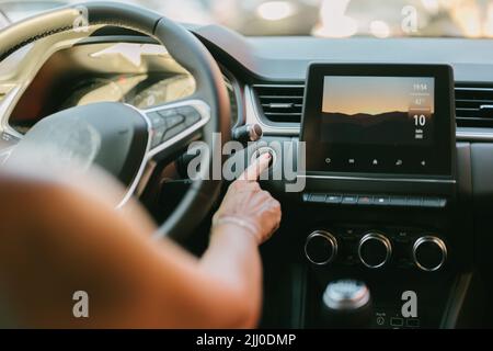 woman pressing the automatic start button on her car Stock Photo