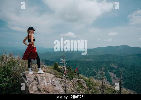 A girl on top of Falaza mountain looks at a beautiful mountain valley. Travel and tourism. Hiking High quality photo Stock Photo