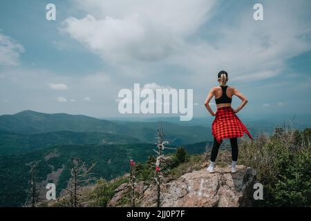 A girl on top of Falaza mountain looks at a beautiful mountain valley. Travel and tourism. Hiking High quality photo Stock Photo