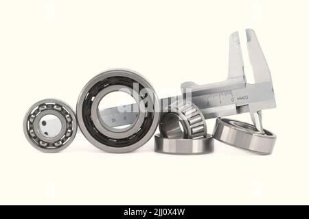 Measure caliper and roller bearings on white background. Mechanical ...