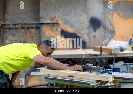 master carpenter adjusting his grinding machine in his workshop Stock Photo