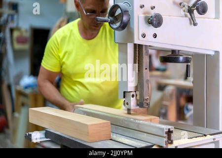 master carpenter adjusting his cutting machine in his workshop Stock Photo