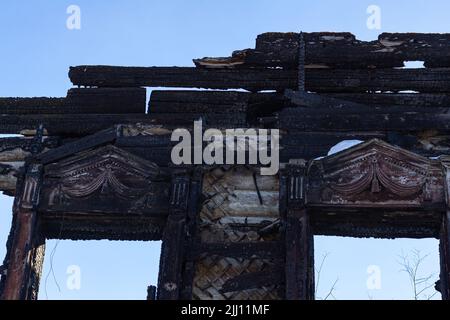 part of window of burnt wooden house without roof. special operation in Ukraine, war destroys houses and people, horror and misery, loss of housing an Stock Photo