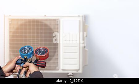 Technician checking the operation of the air conditioner Stock Photo