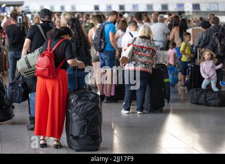 22 July 2022, Hessen, Frankfurt/Main: Thousands of passengers are waiting to check in at the airport's check-in counters. In view of the start of the vacations in several German states, airport operator Fraport is expecting a record rush. Around 200,000 passengers per day are expected on each of the weekends from July 22 to 24, 2022. Photo: Boris Roessler/dpa Stock Photo