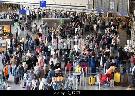 22 July 2022, Hessen, Frankfurt/Main: Thousands of passengers are waiting to check in at the airport's check-in counters. In view of the start of the vacations in several German states, airport operator Fraport is expecting a record rush. Around 200,000 passengers per day are expected on each of the weekends from July 22 to 24, 2022. Photo: Boris Roessler/dpa Stock Photo
